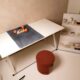 Detailed architectural blueprint for a home renovation spread across a clean, modern desk with design tools, symbolizing s...