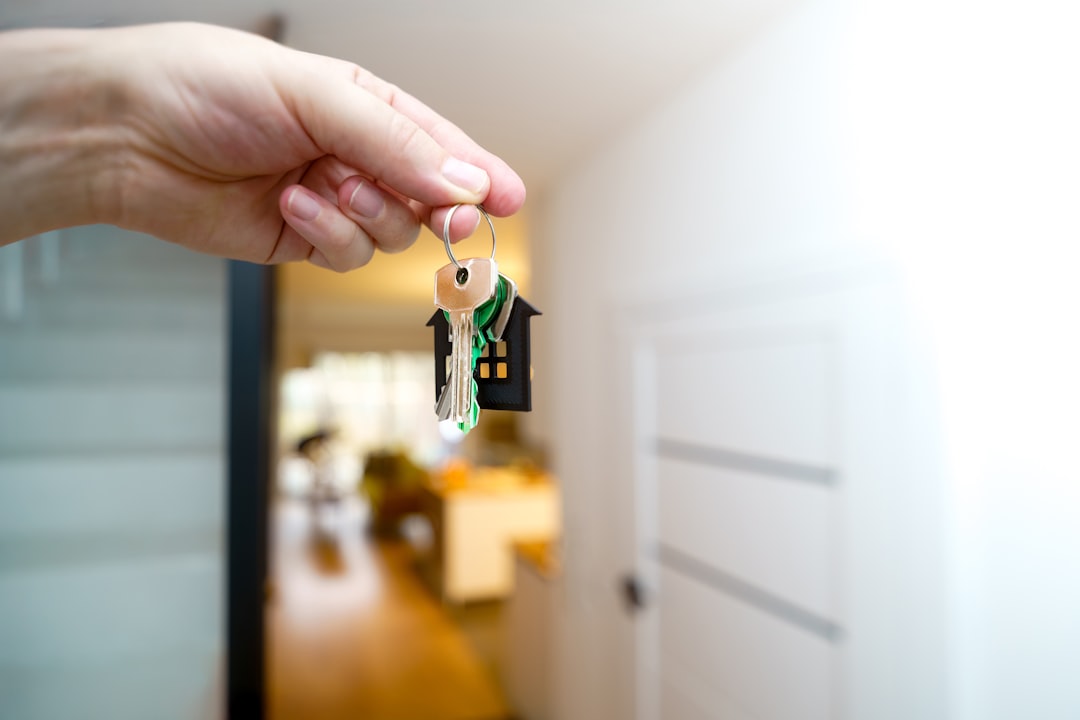 A minimalist photo of hands holding house keys next to a calculator on a clean surface, symbolizing the costs and savings of real estate commissions.