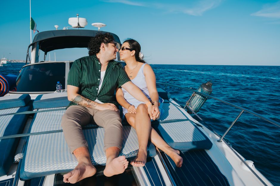 A happy couple smiles and relaxes on the deck of their boat on a bright, sunny day, embodying the financial freedom and lifestyle achieved by making a smart financial move.